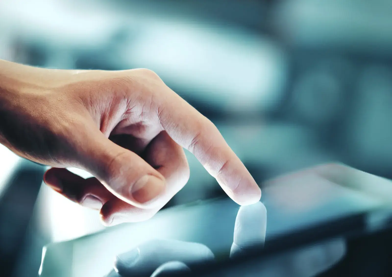 Hand touching an illuminated touchscreen