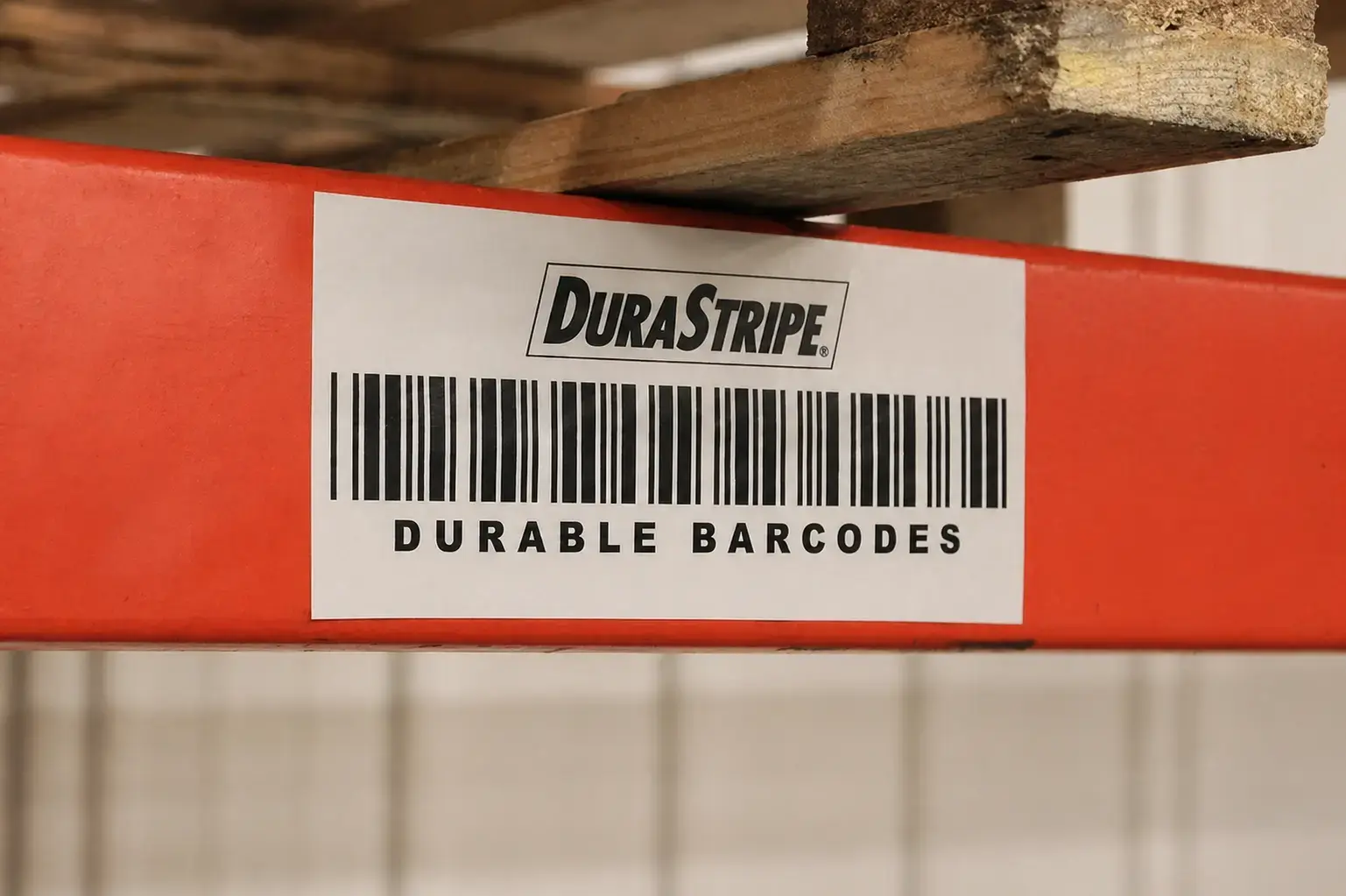 Witte DuraStripe barcode sticker op een rode magazijnstelling, toegepast als duurzame identificatielabeling voor logistiek en voorraadbeheer.