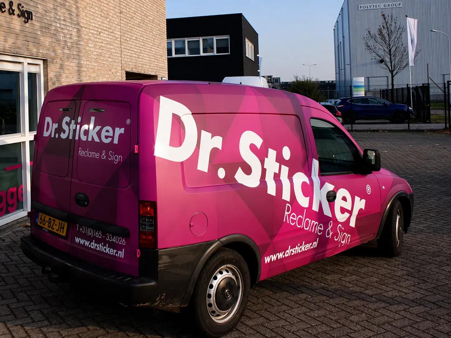 Felroze bedrijfsbus met volledige voertuigbelettering en carwrap van Dr.Sticker Reclame & Sign, voorzien van grote witte logoletters en geometrisch patroon, geparkeerd op een bedrijventerrein voor een bedrijfspand.