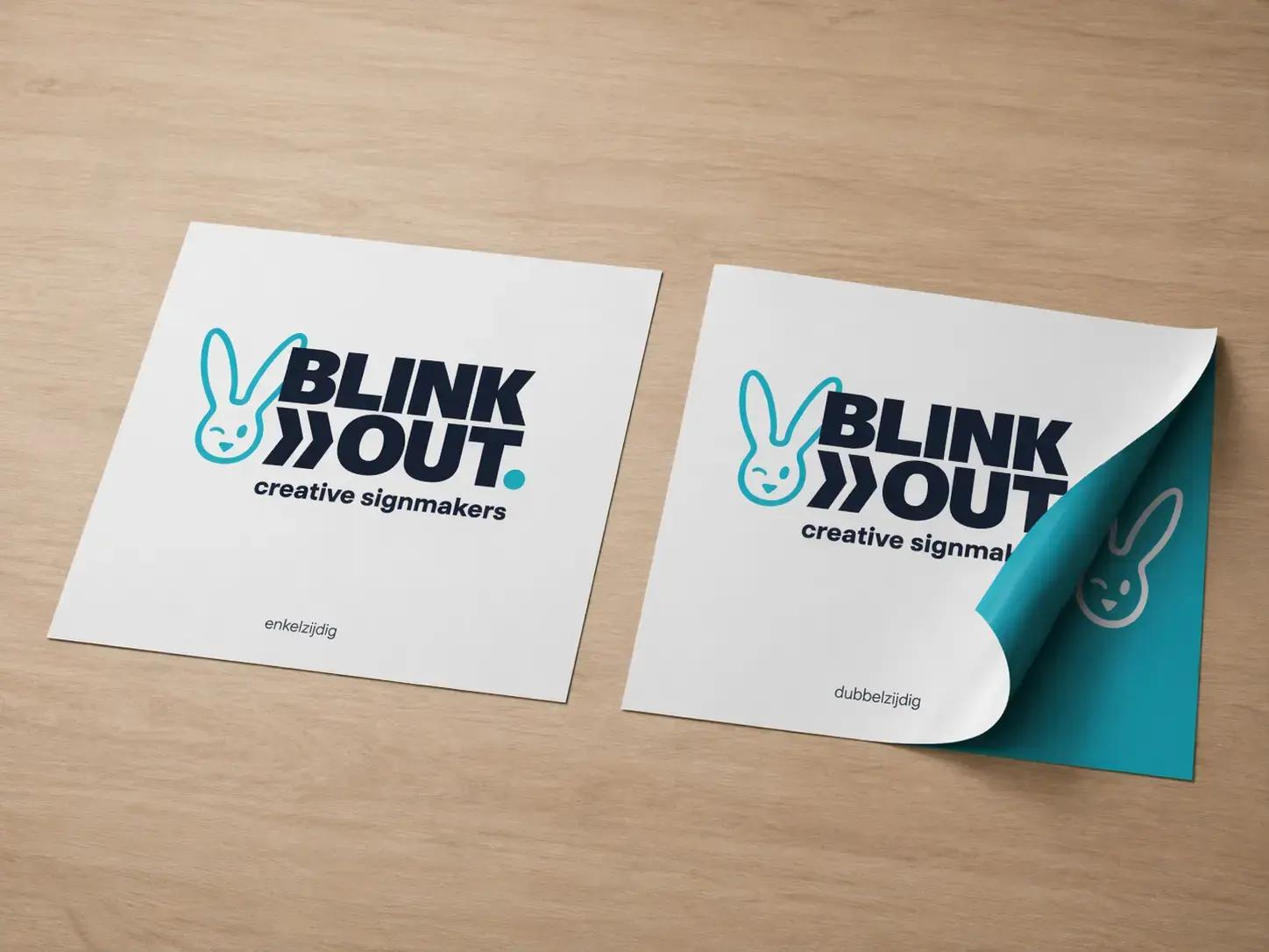 Twee vierkante BLINK OUT creative signmakers-printstalen op hout, met vergelijking tussen enkelzijdige en dubbelzijdige print waarbij de omgeslagen hoek de bedrukte achterzijde toont.