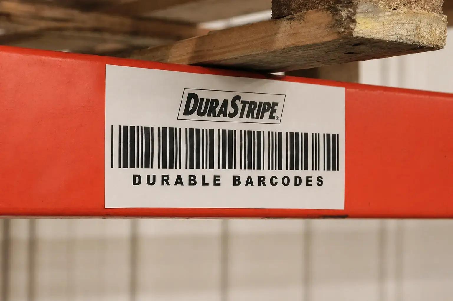 Witte DuraStripe barcode sticker op een rode magazijnstelling, toegepast als duurzame identificatielabeling voor logistiek en voorraadbeheer.