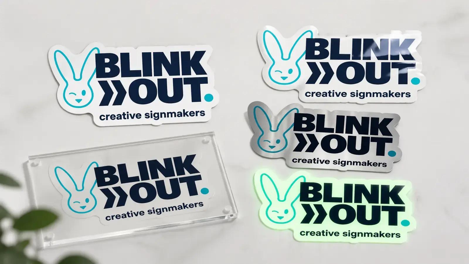 Overzicht van BLINK OUT creative signmakers-logo’s als signmaking sample set, uitgevoerd in contourgesneden plaatmateriaal, transparant acrylaat, geborsteld metaal, glanzende afwerking en lichtgevende uitvoering.