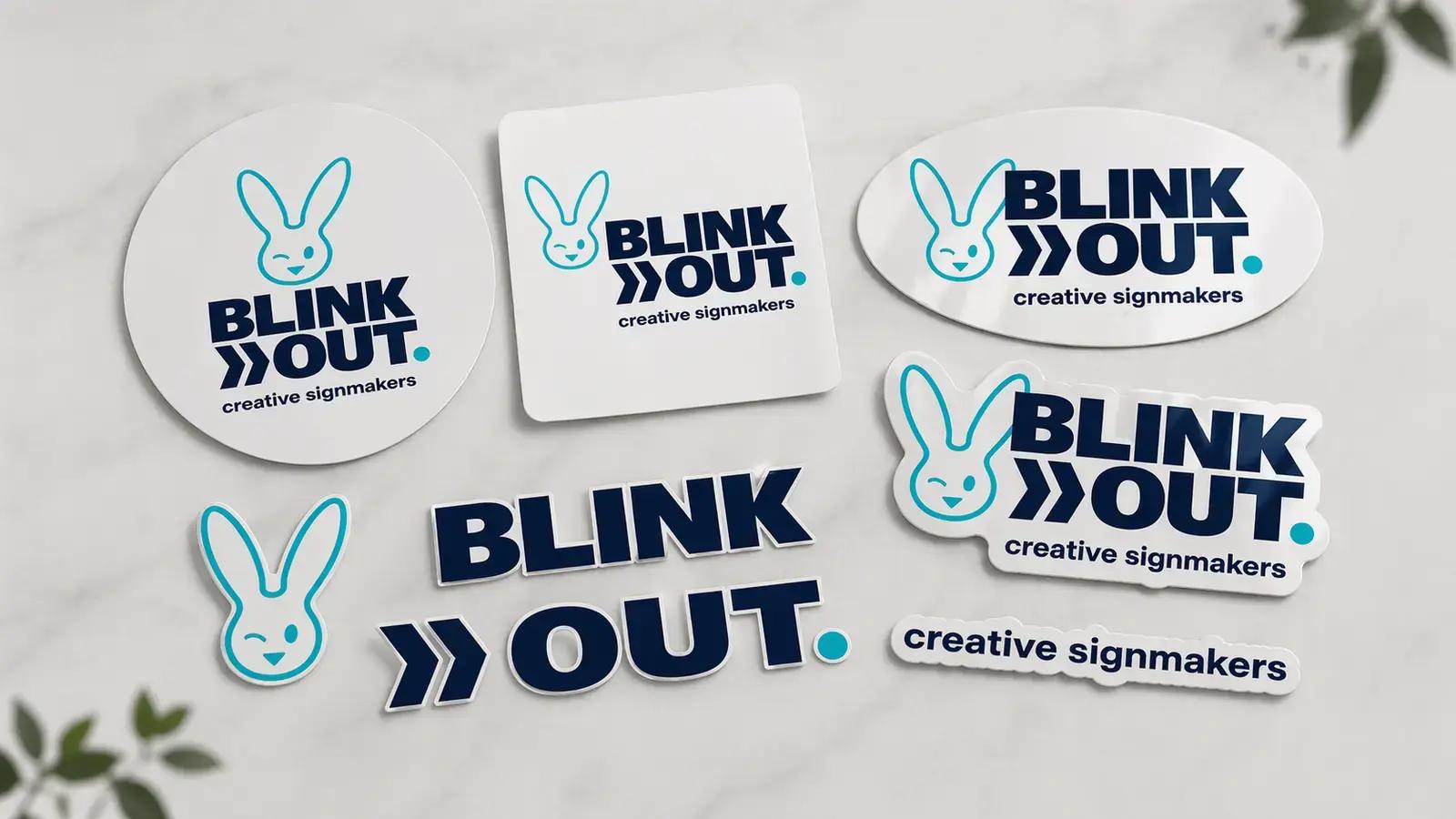 Overzicht van BLINK OUT creative signmakers-logo in verschillende vormen en signmaking toepassingen, waaronder ronde, ovale, rechthoekige en contourgesneden stickers en losse logo-elementen op een lichte ondergrond.