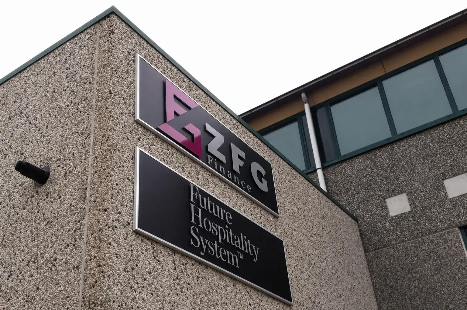 Twee gevelborden op een grindbetonnen bedrijfspand met RFG Finance-logo en de tekst Future Hospitality System op donkere panelen.