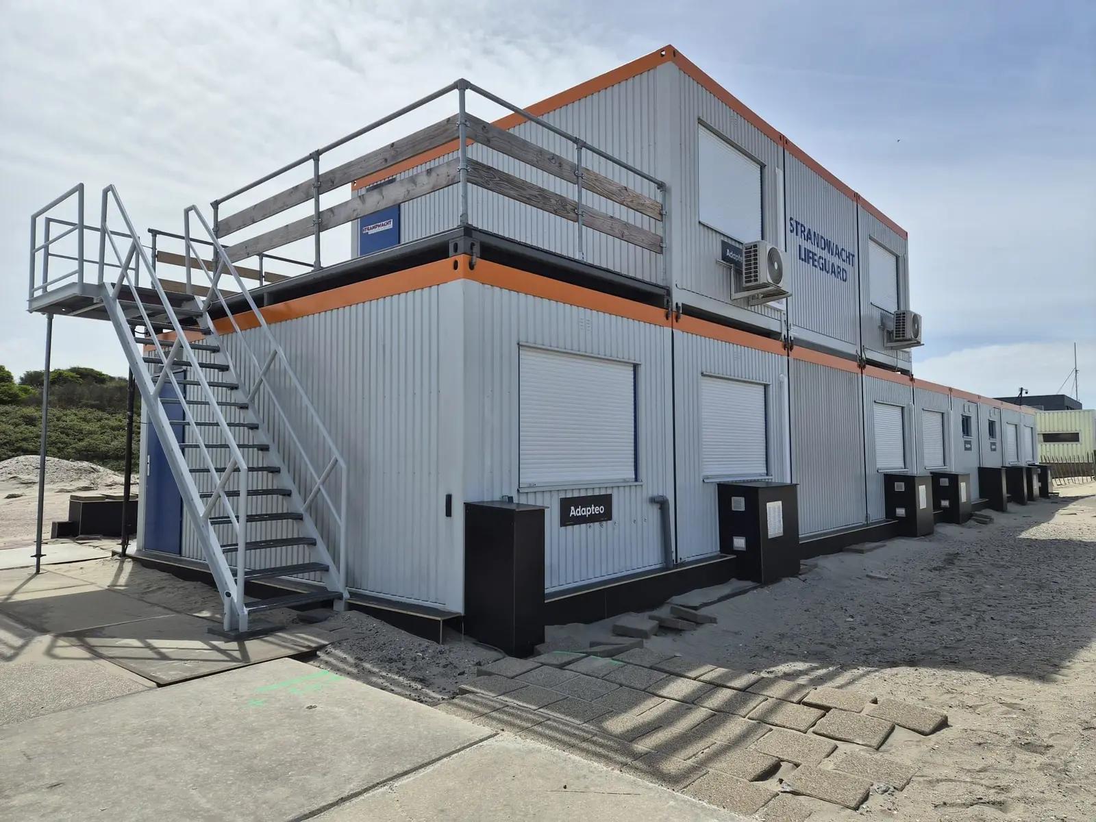 Adapteo beach post in Hoek van Holland with an orange roofline and blue lifeguard lettering.
