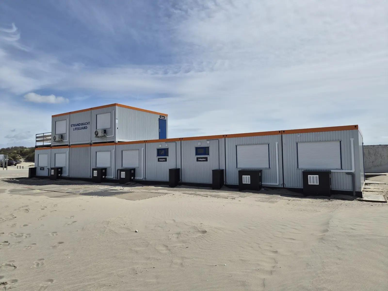 De strandpost met de beletterde verdieping boven de modulaire units.