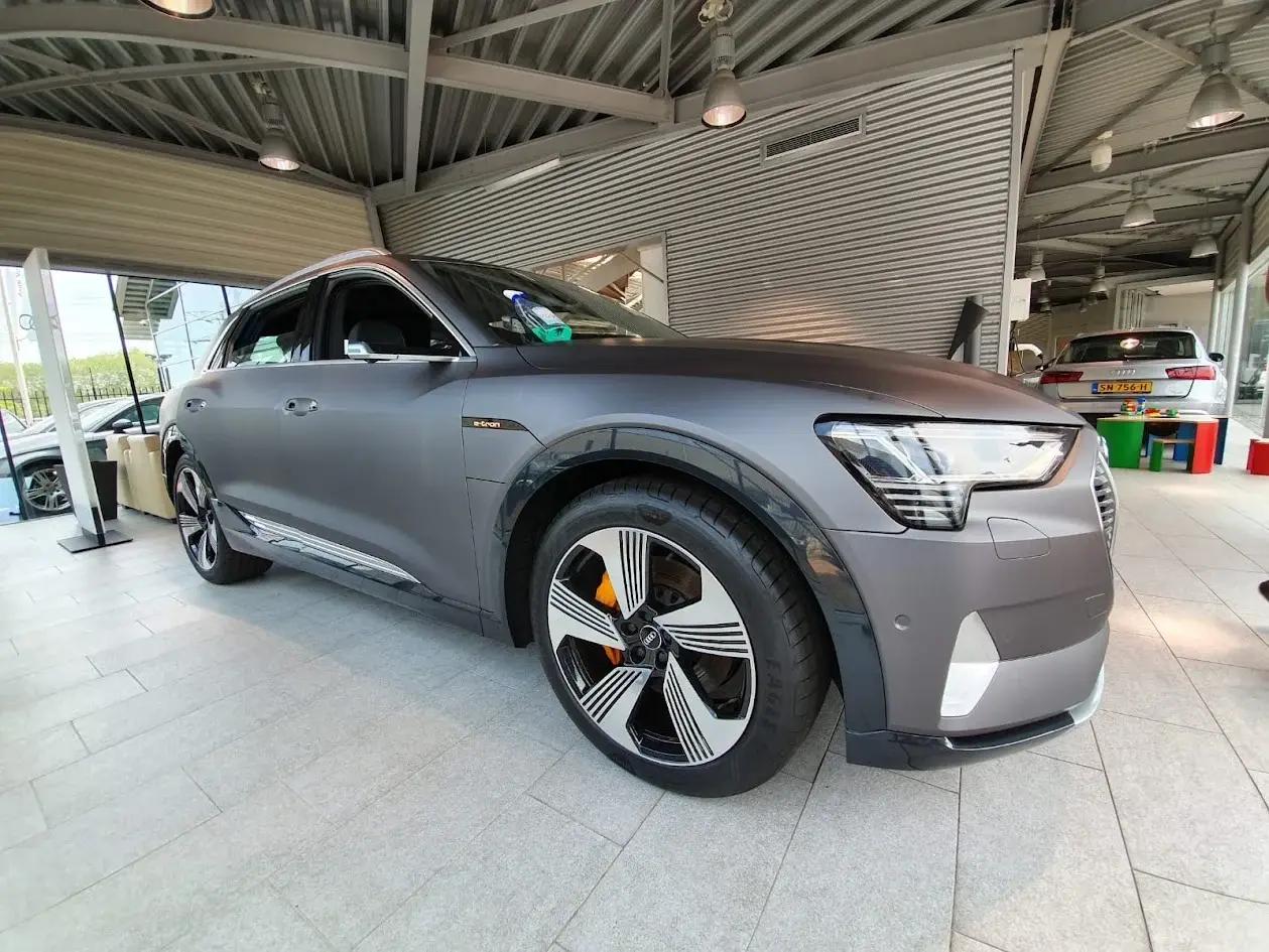 Audi e-tron with a matt grey wrap, photographed in a showroom.
