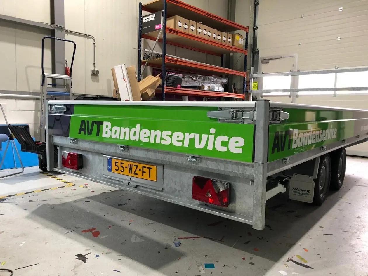 Open AVT Bandenservice trailer with green panels and white company lettering.