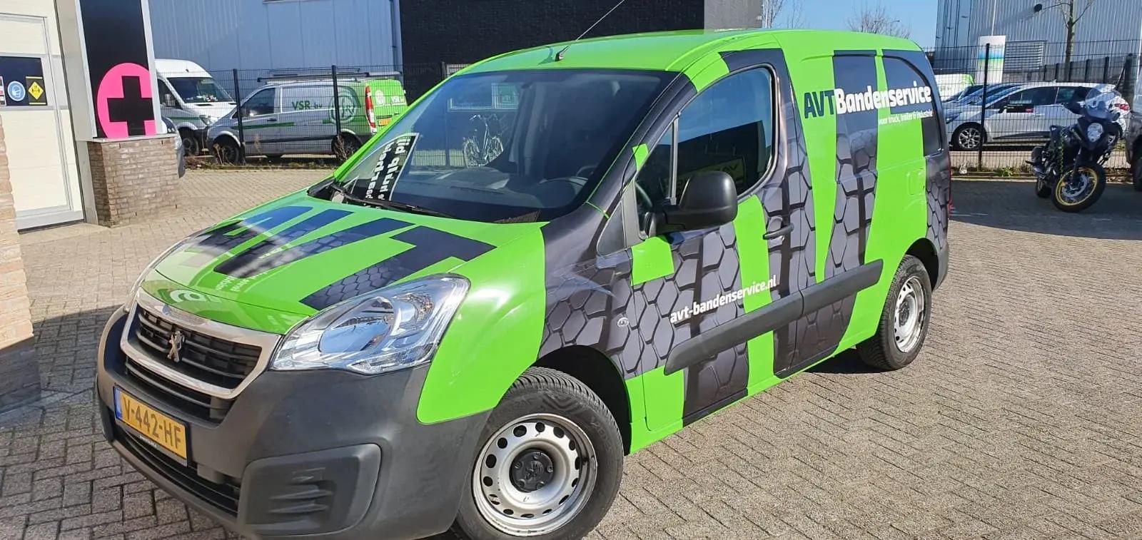 Peugeot business van with a green AVT Bandenservice wrap and tyre pattern.