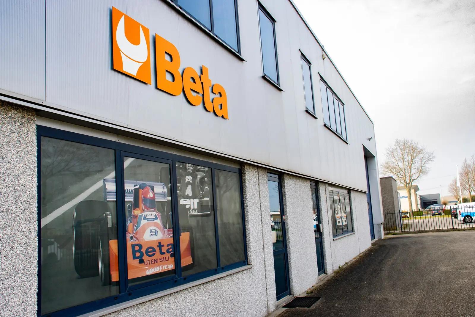 Oranje Beta-logo boven de bedrukte ramen