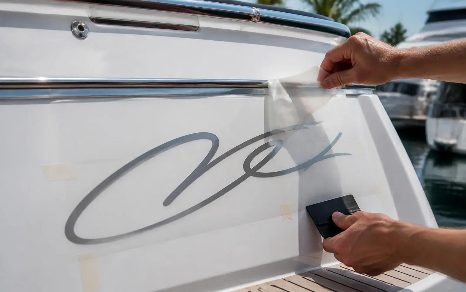 Montage van naambelettering op de spiegel van een boot
