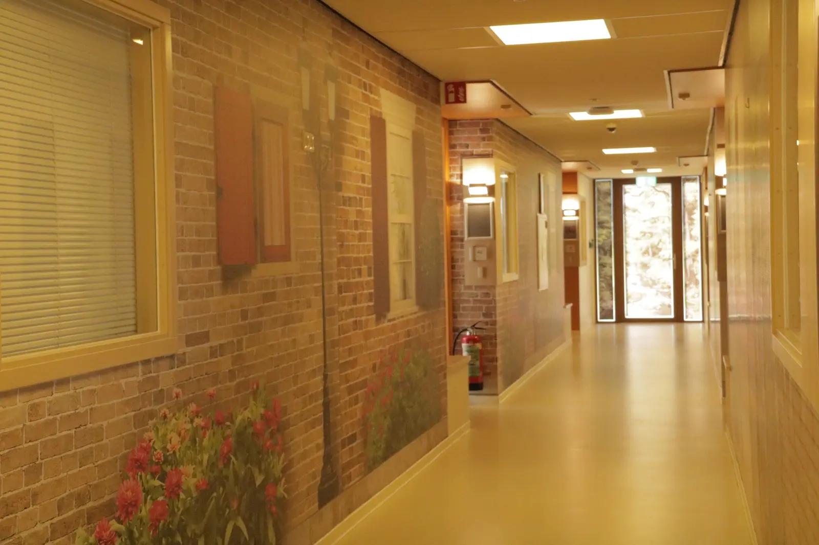 Corridor with brickwork and floral wall graphics at Bloemschevaert