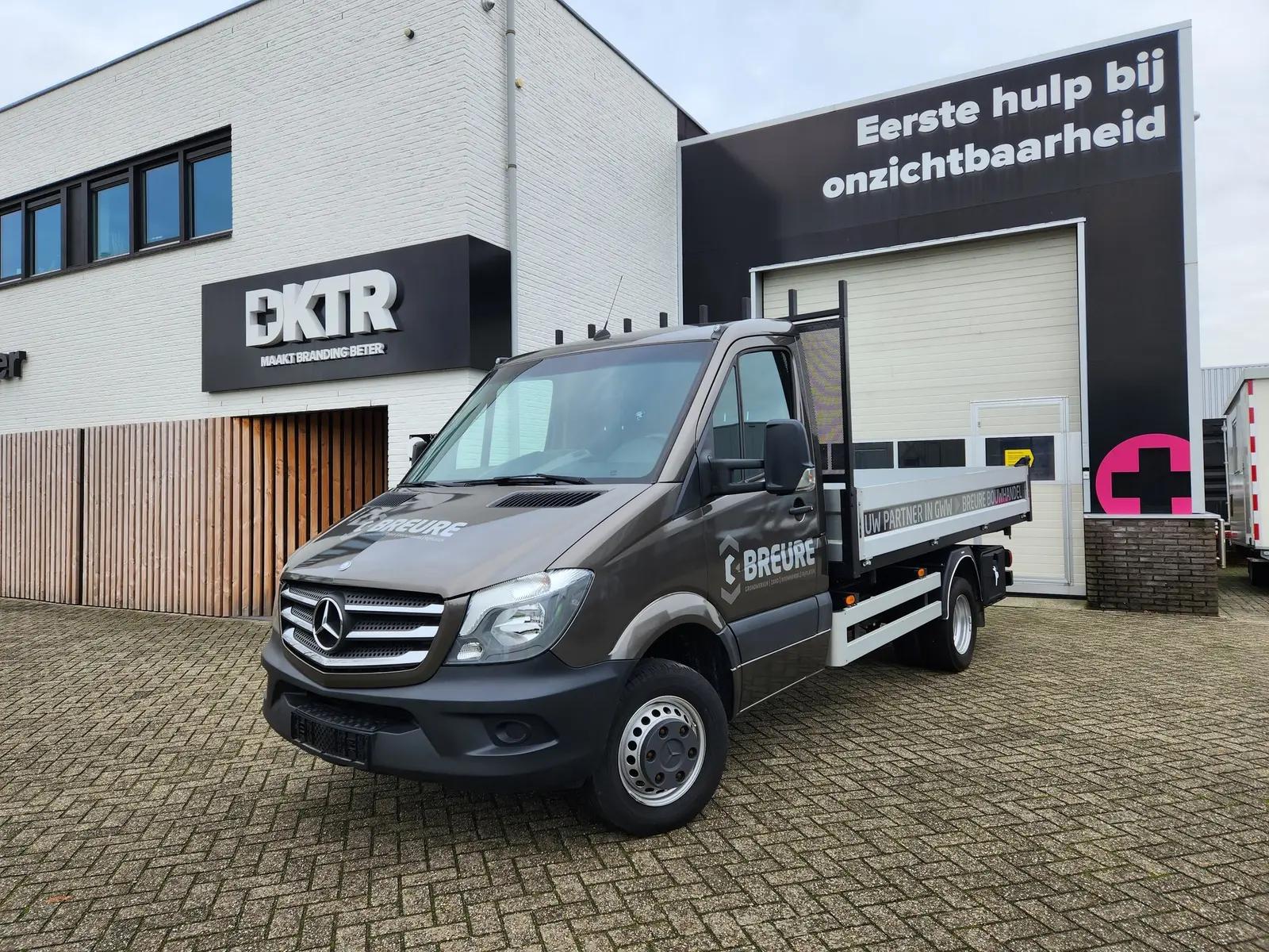 Breure-bedrijfswagen met donkere cabine en witte bedrijfsnaam op de deur.
