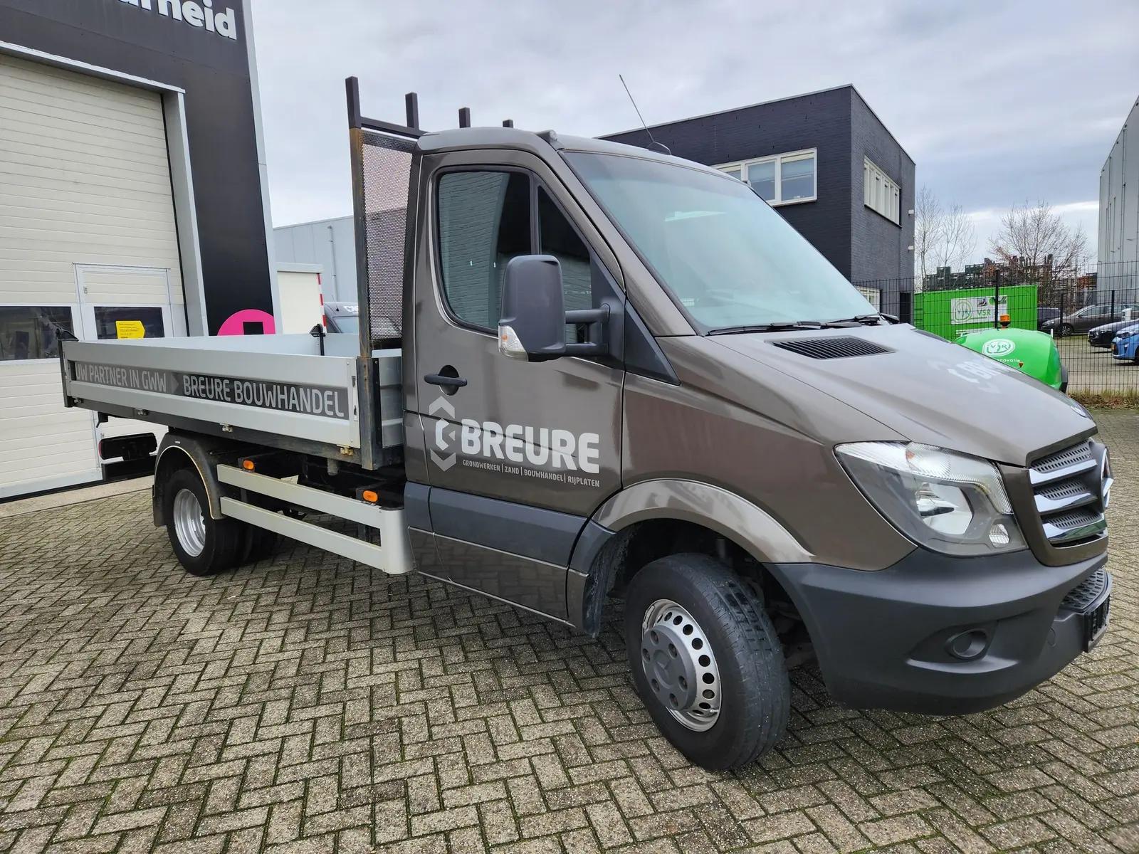 Schuin vooraanzicht van de Breure-cabinewrap en het deur-logo.