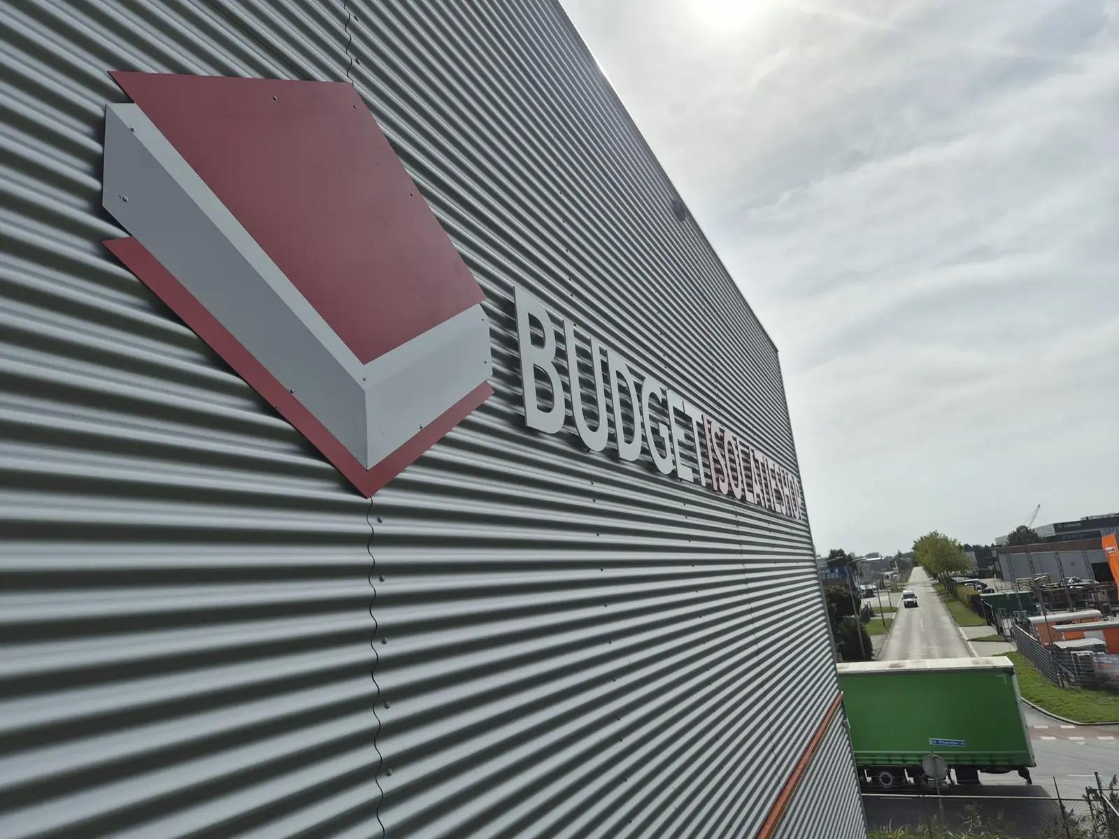 Schuin zijaanzicht van het uitgesneden logo en de gevelletters op de ribbelgevel van Budget Isolatieshop.