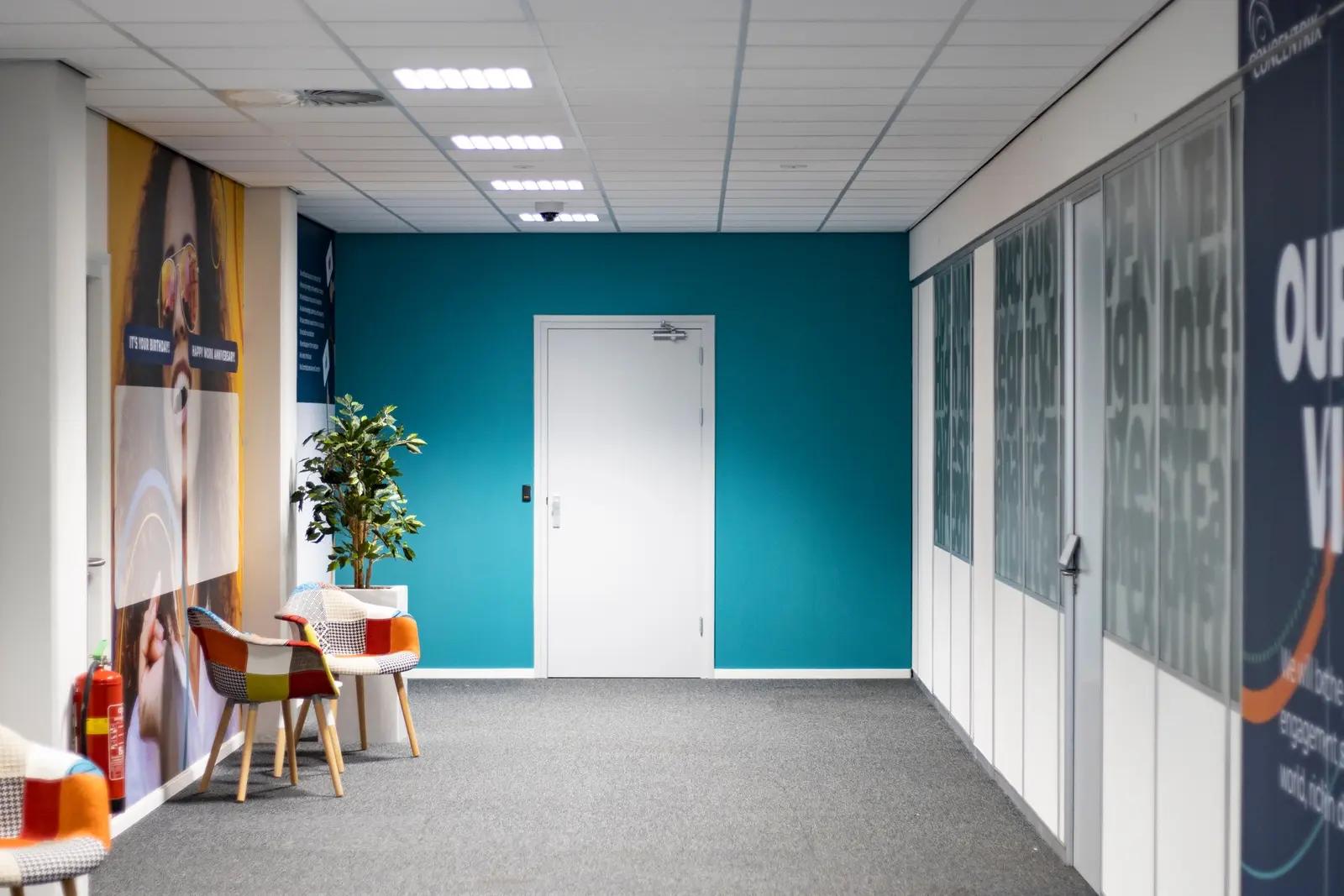 Grafische glasfolie langs de gang in het Concentrix-kantoor