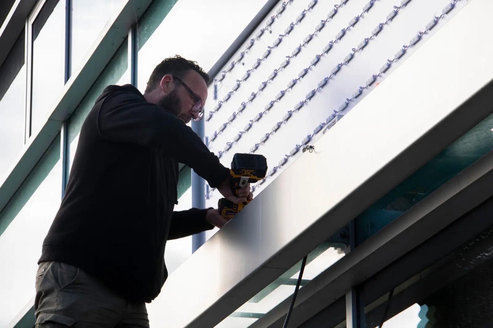 Montage van de lichtreclame boven de glaspui