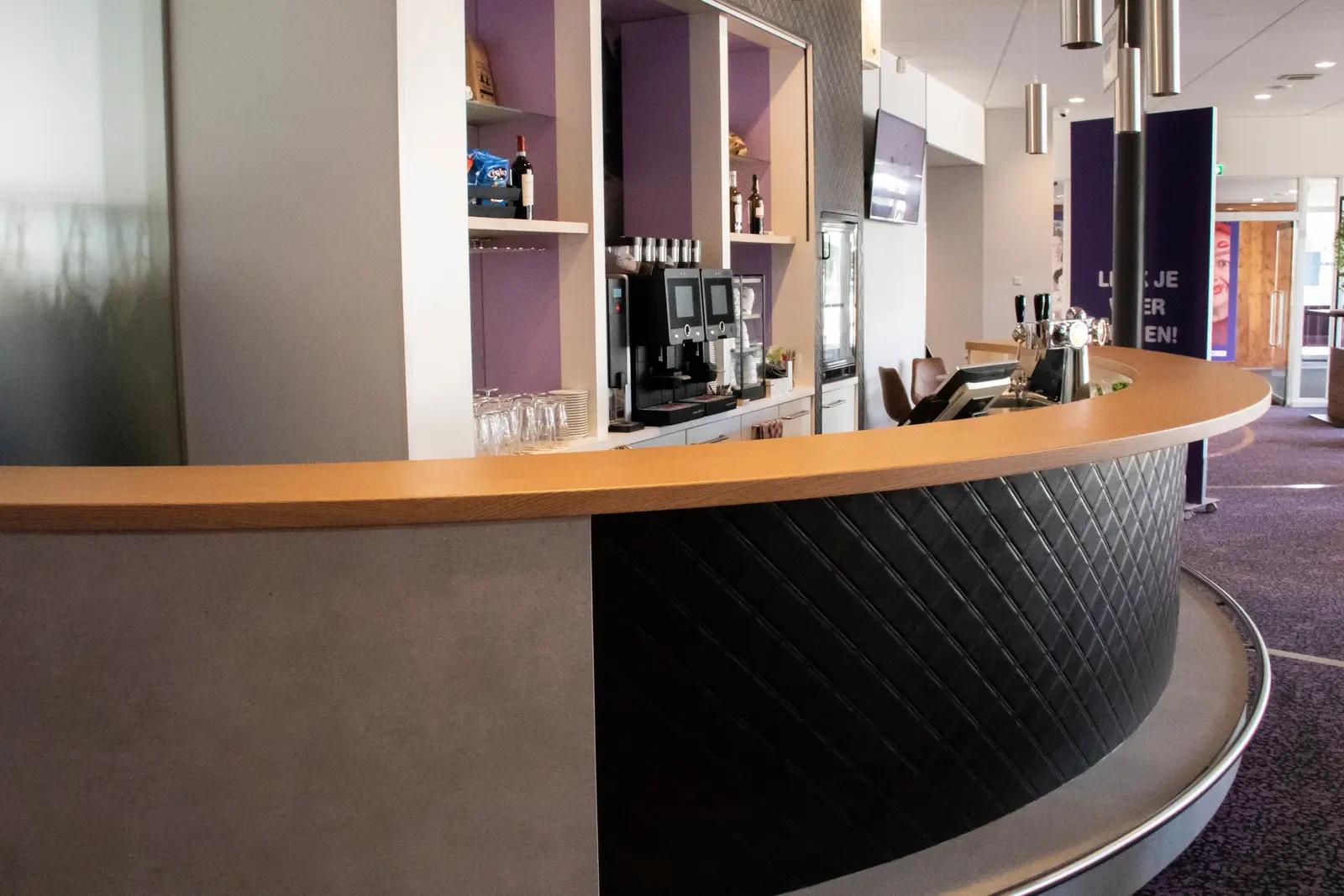 Curved foyer bar at Theater De Kring with wood-effect counter