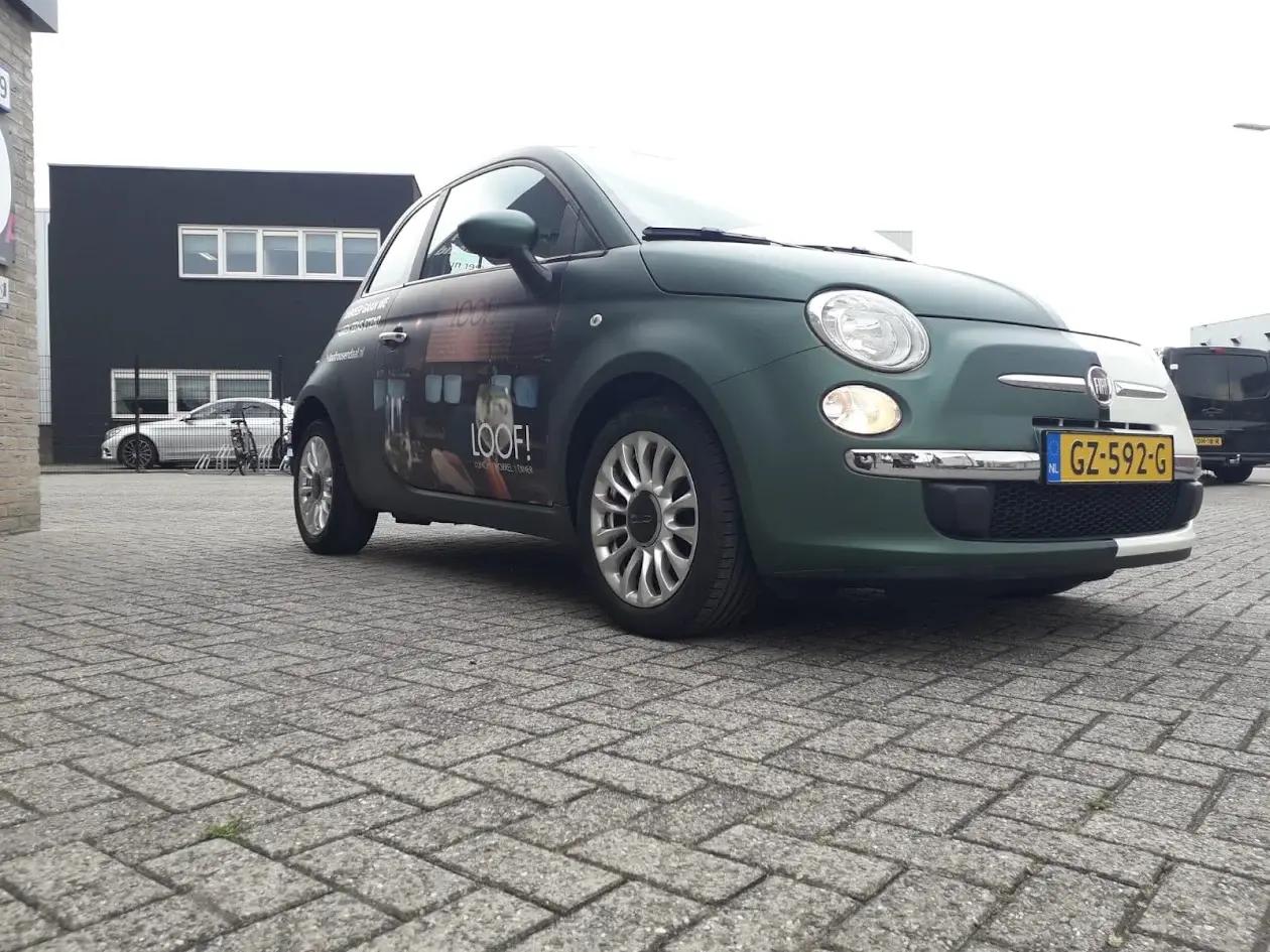 Fiat 500 with a dark green matt finish and advertising on the side.