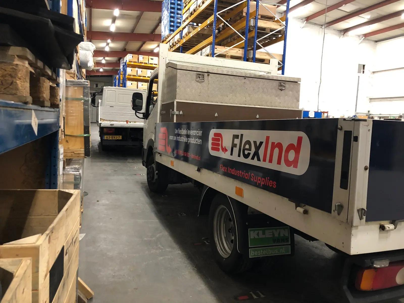 FlexInd graphics on the side of a work vehicle in the workshop.