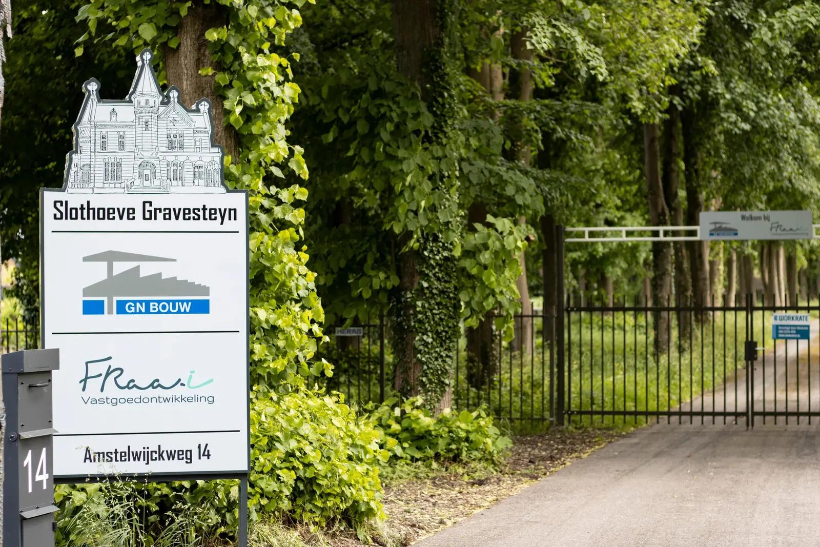 Shaped entrance sign at Slothoeve Gravesteyn with company logos