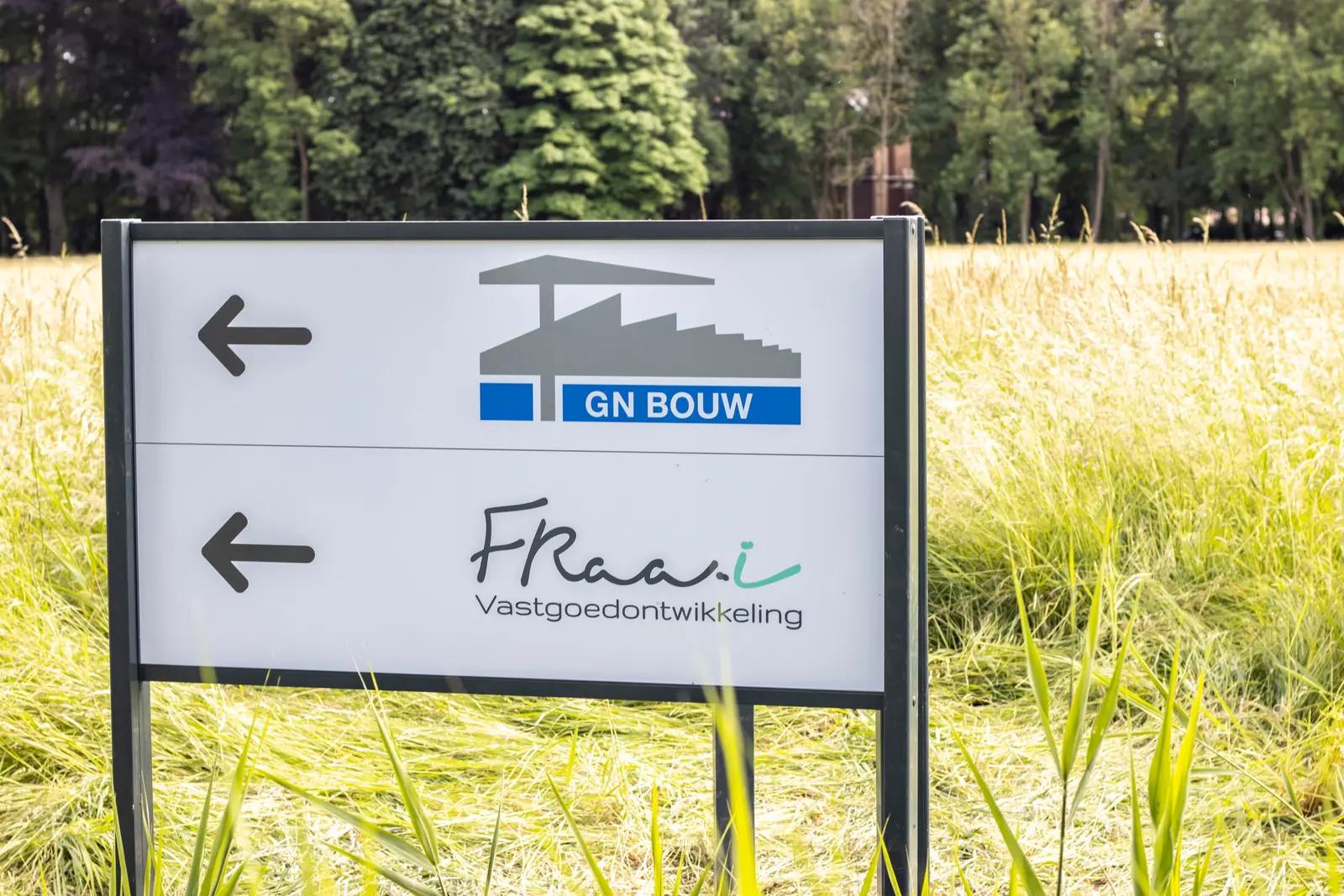 Freestanding directional sign with two company names and arrows