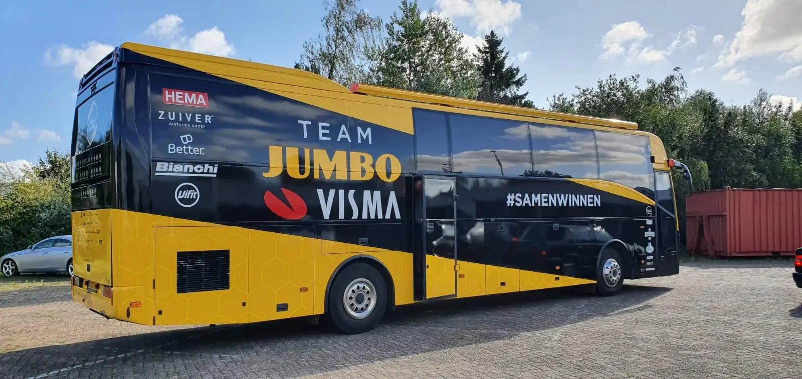 Yellow and black Team Jumbo-Visma coach with a large logo and sponsor graphics