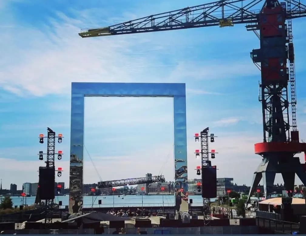 Large silver reflective scenic frame at a waterside event