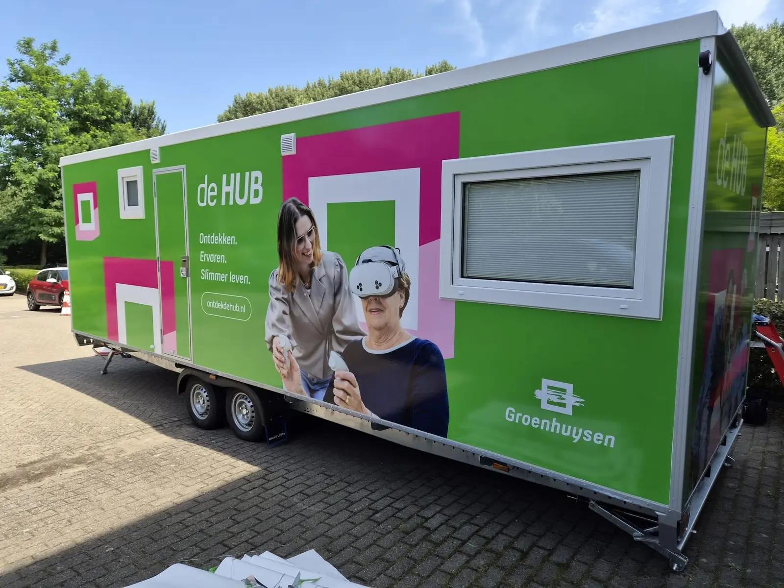 Mobiele HUB Express met groene en roze graphics en een groot fotografisch beeld op de zijkant.