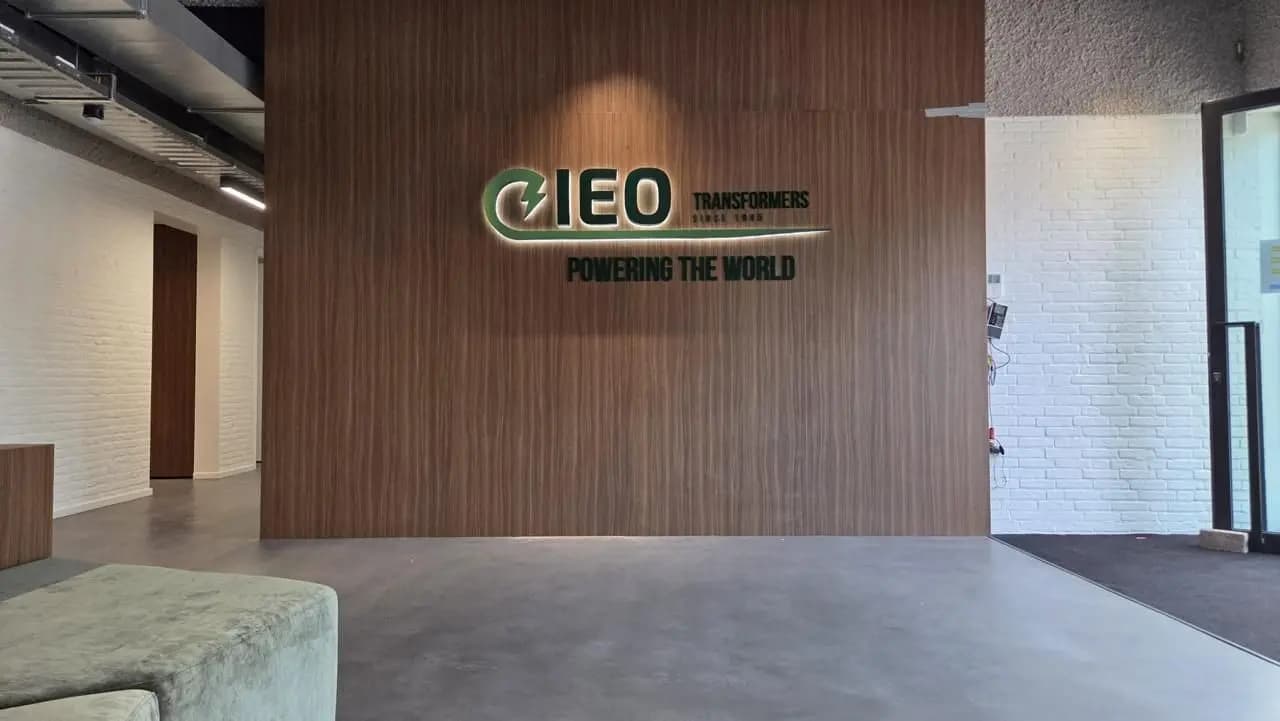 Green IEO logo with halo lighting and Powering the world lettering on a timber entrance wall.