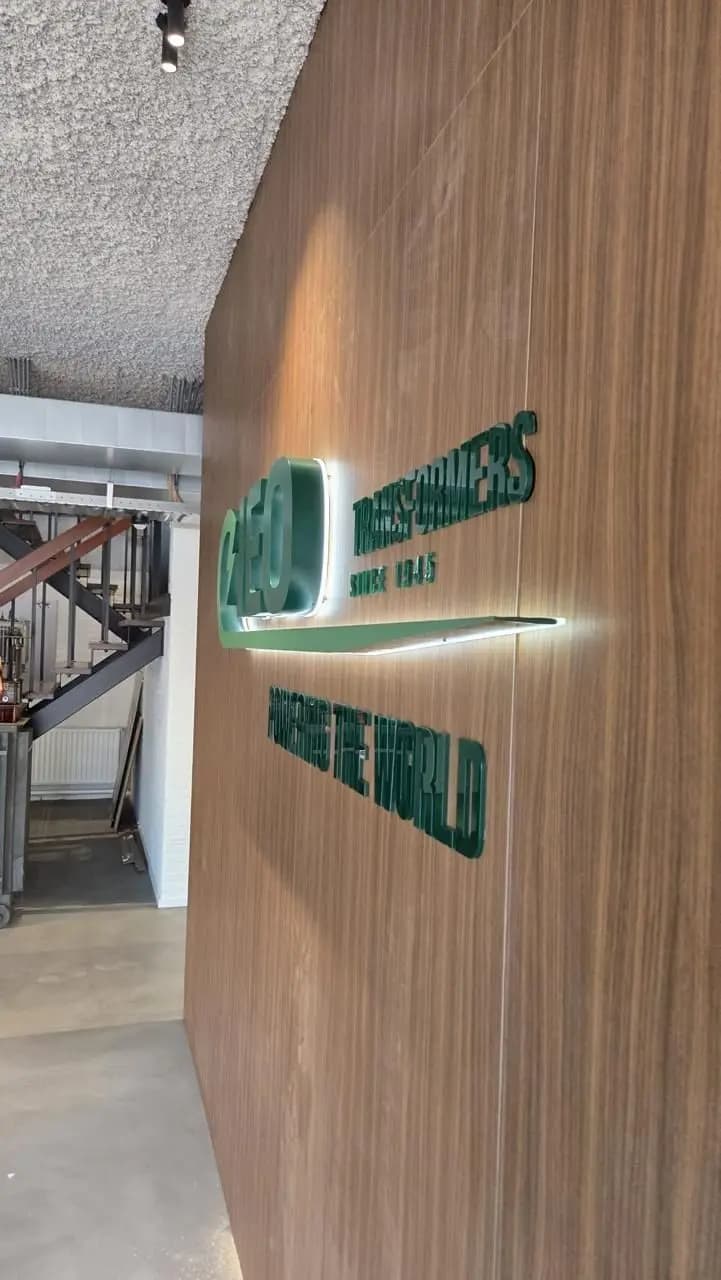 Zijaanzicht van de groene letters met zichtbare diepte en indirect licht achter het logo.