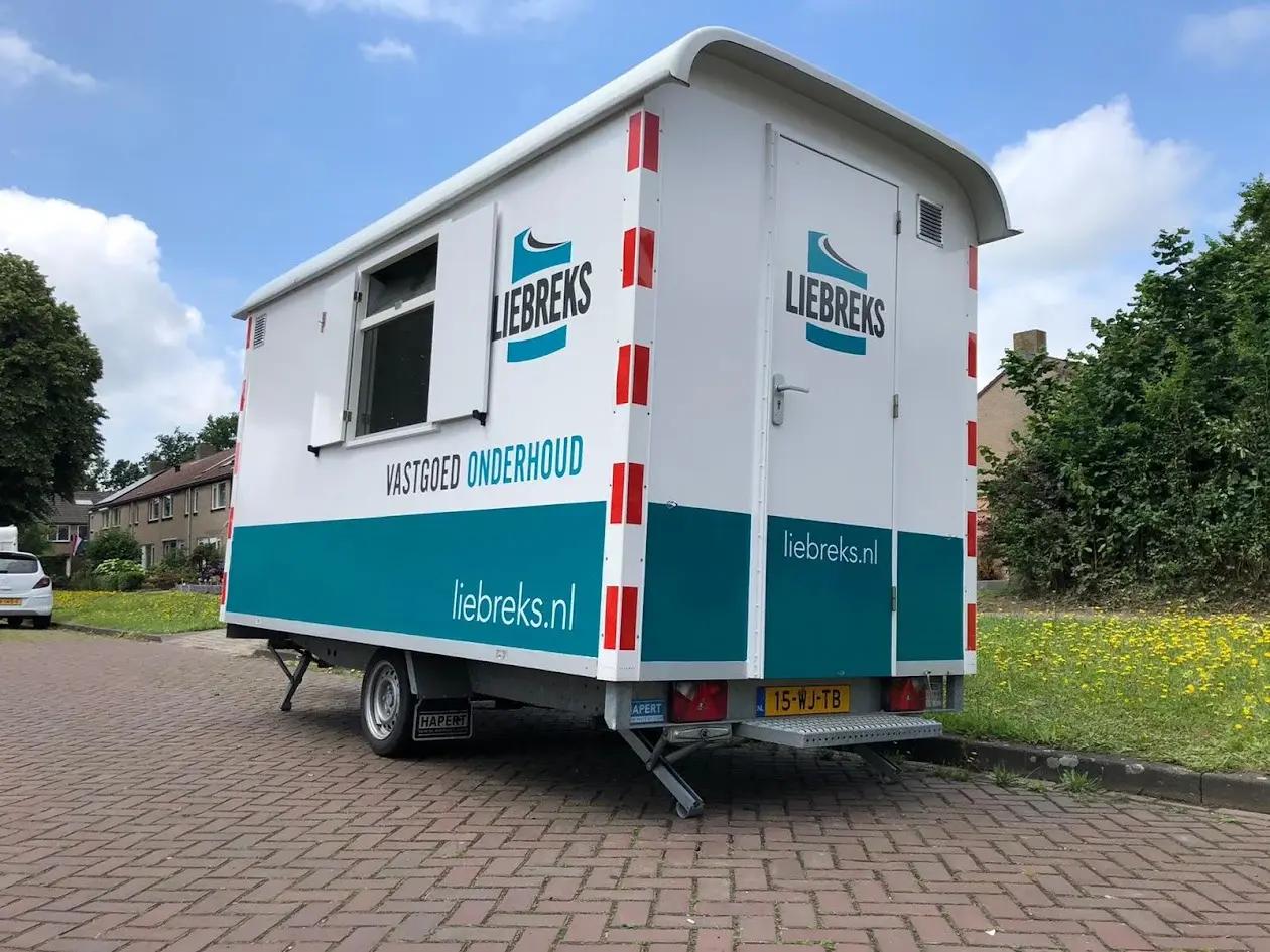 Liebreks site welfare trailer with logo lettering, turquoise panels and a website address.
