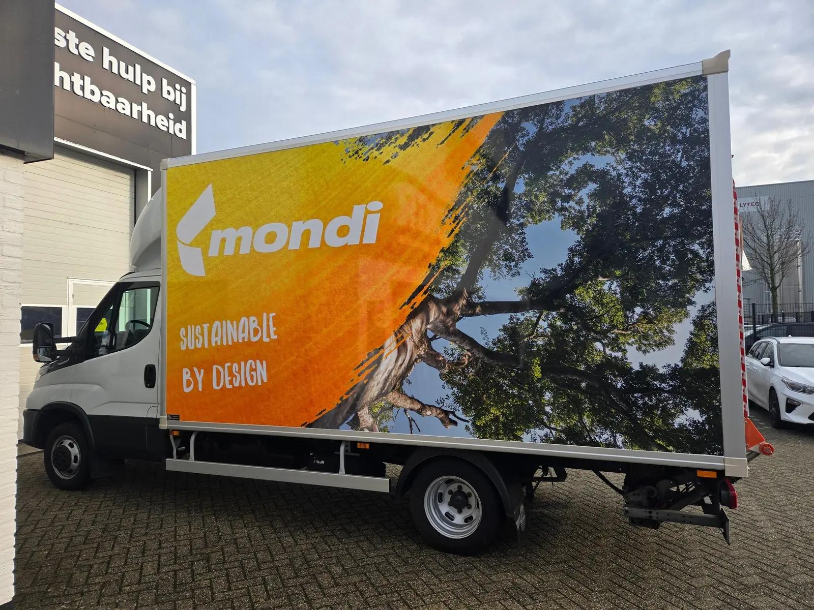 Opposite side of the Mondi box van with a large orange panel and tree photography.
