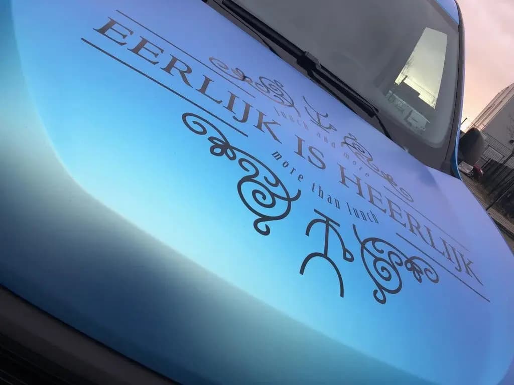Bonnet with blue-green effect film and Eerlijk is Heerlijk lettering.