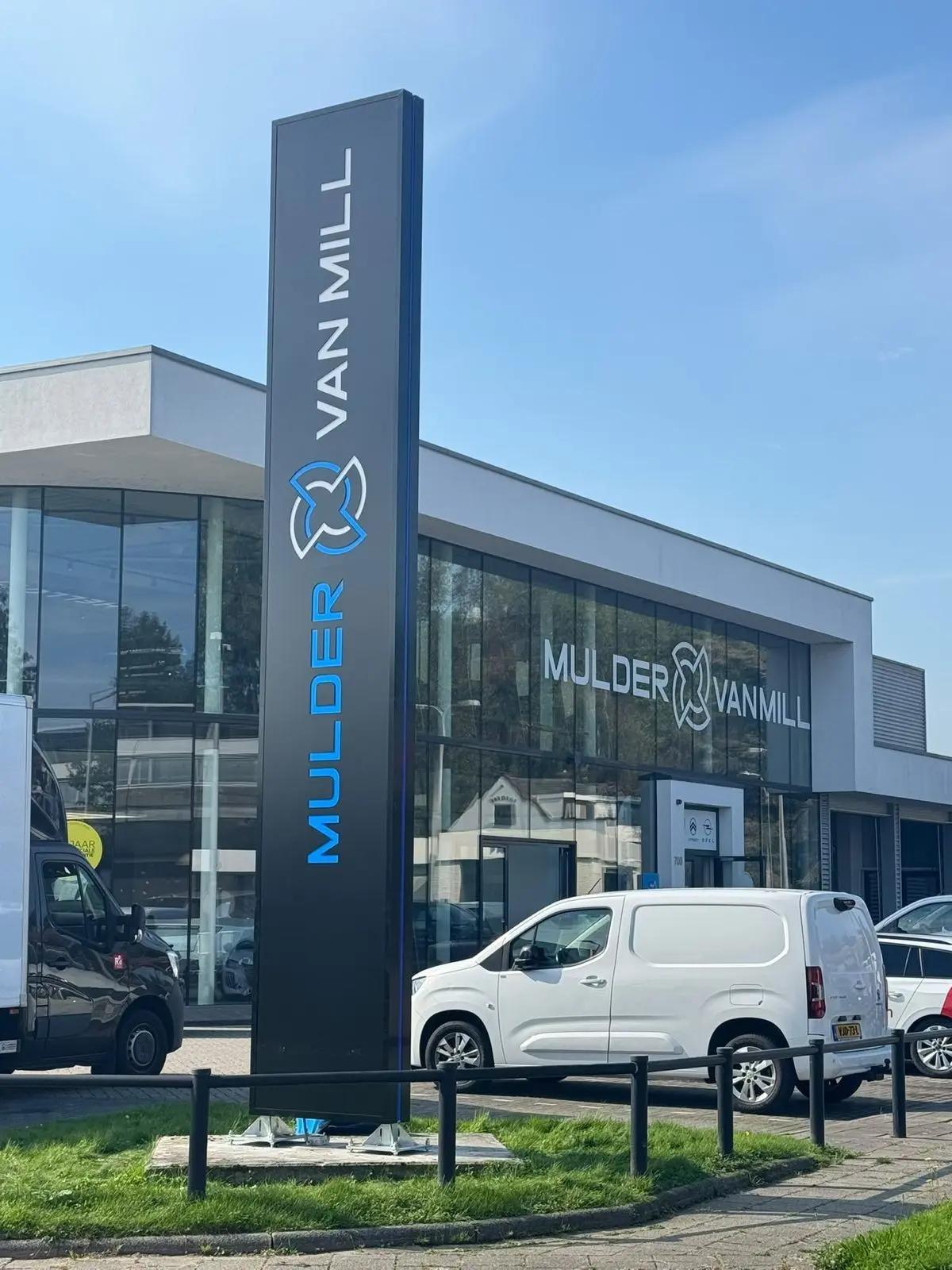 De hoge Mulder van Mill-zuil voor de glazen gevel van de showroom.