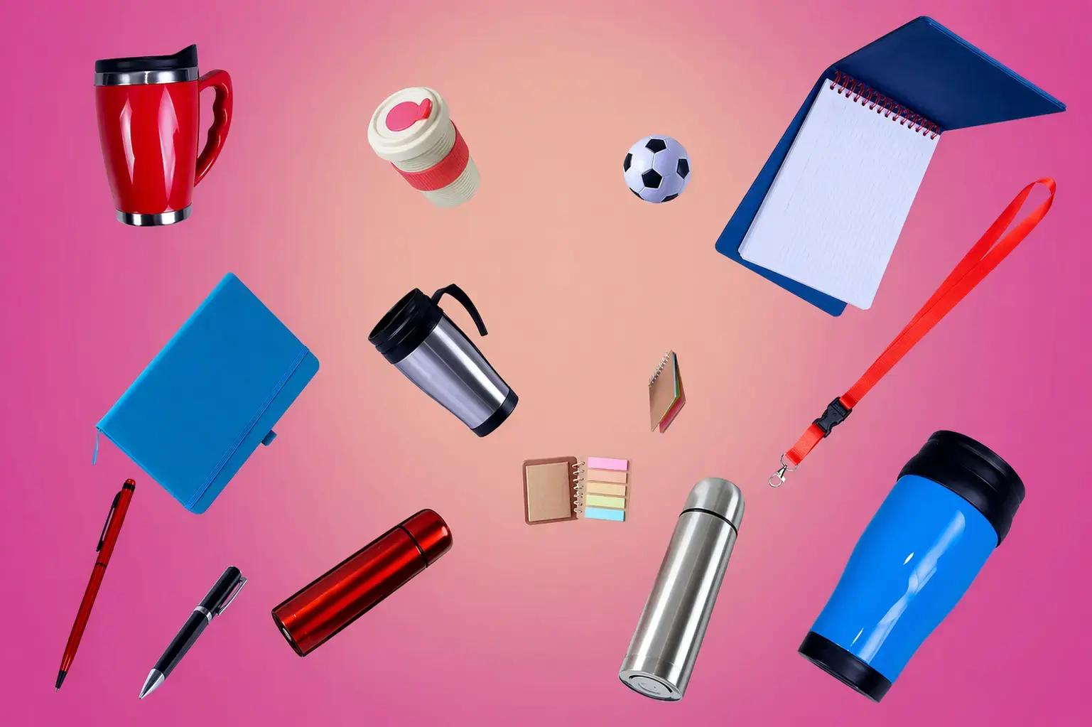 Samenstelling van promotieartikelen zoals mokken, thermosbekers, notitieboekjes, pennen, thermosflessen en een keycord op een roze achtergrond.