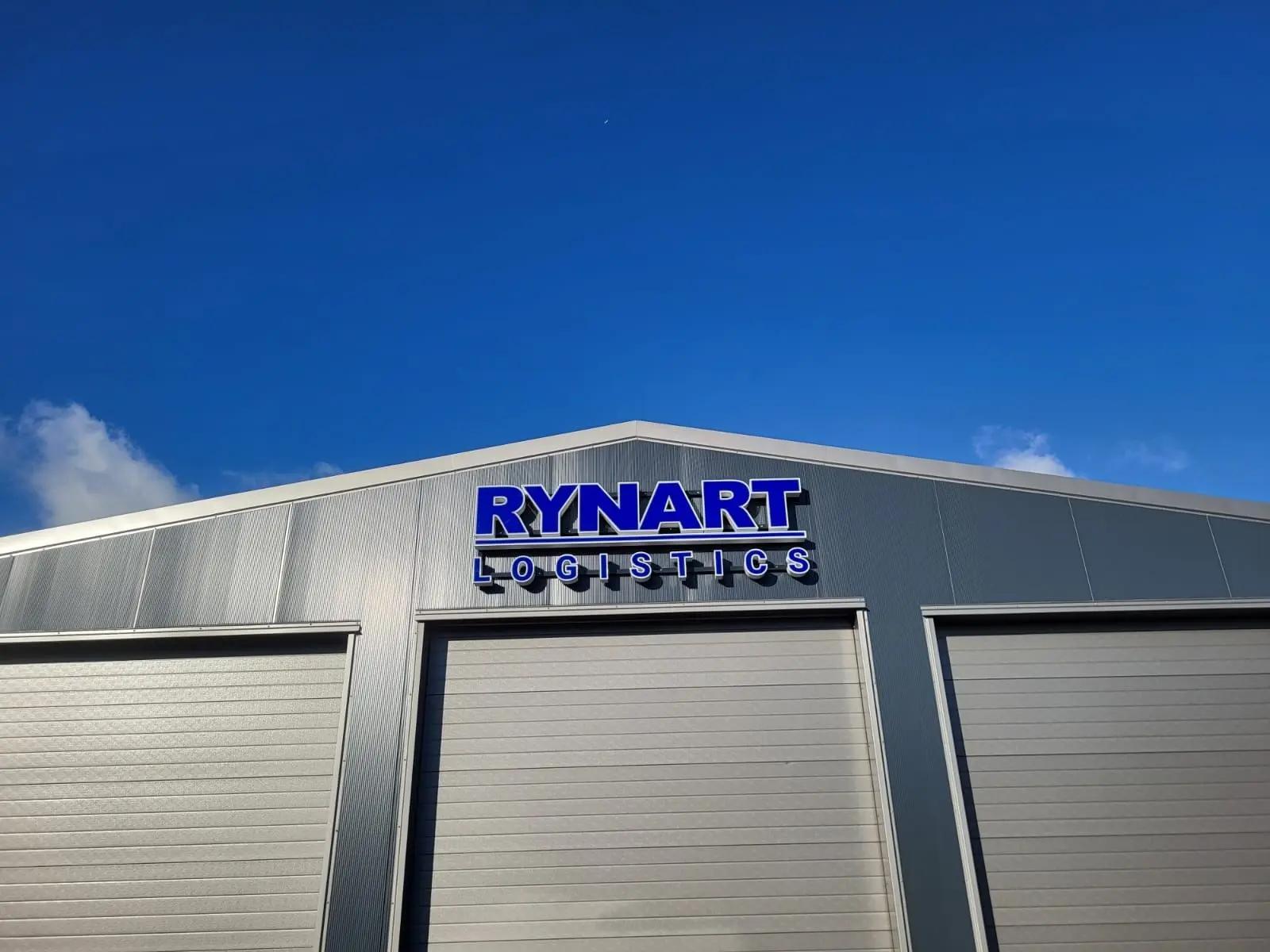 Blue and white Rynart Logistics fascia letters above the central warehouse door.