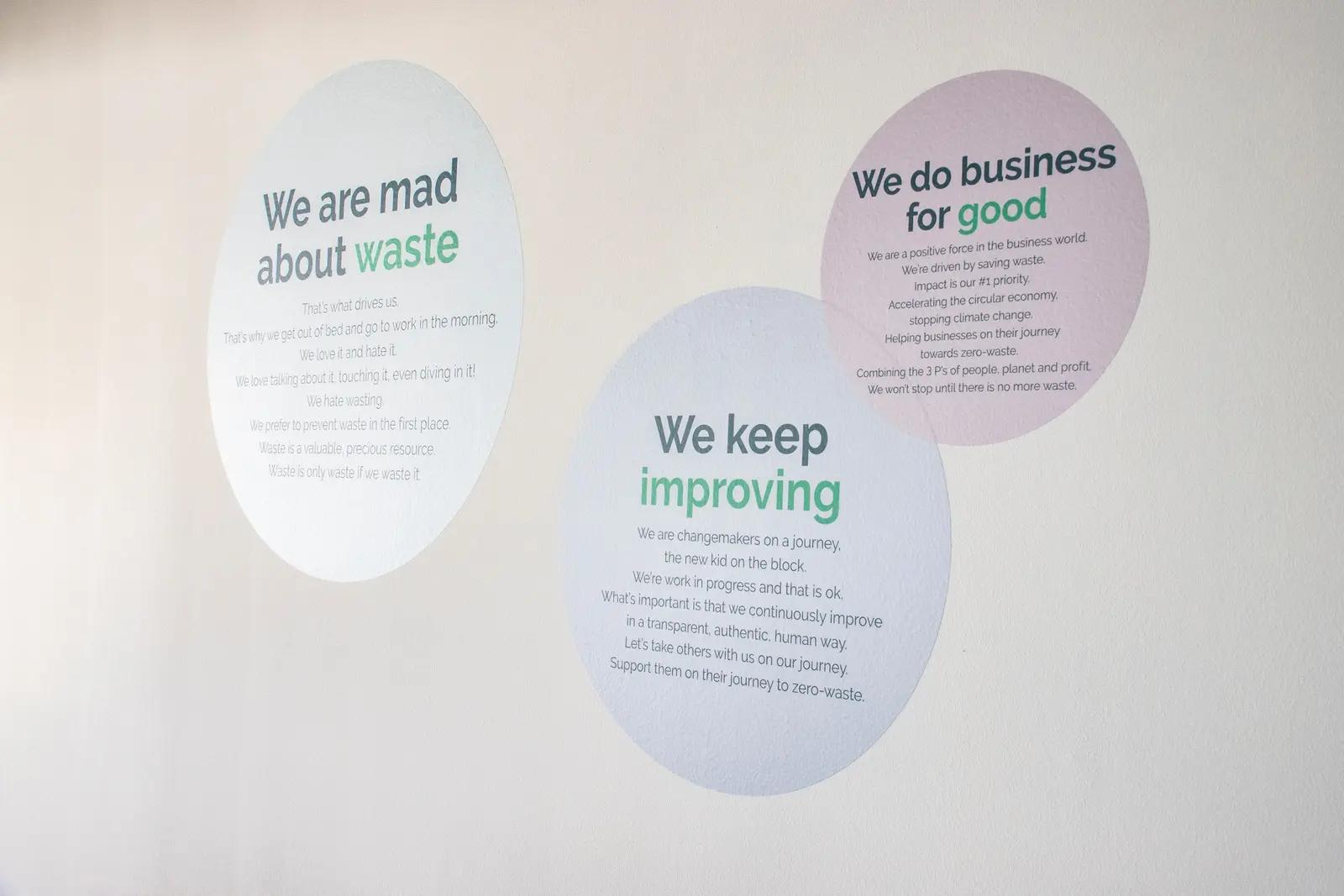 Drie ronde pastelgraphics met merkwaarden op de wand