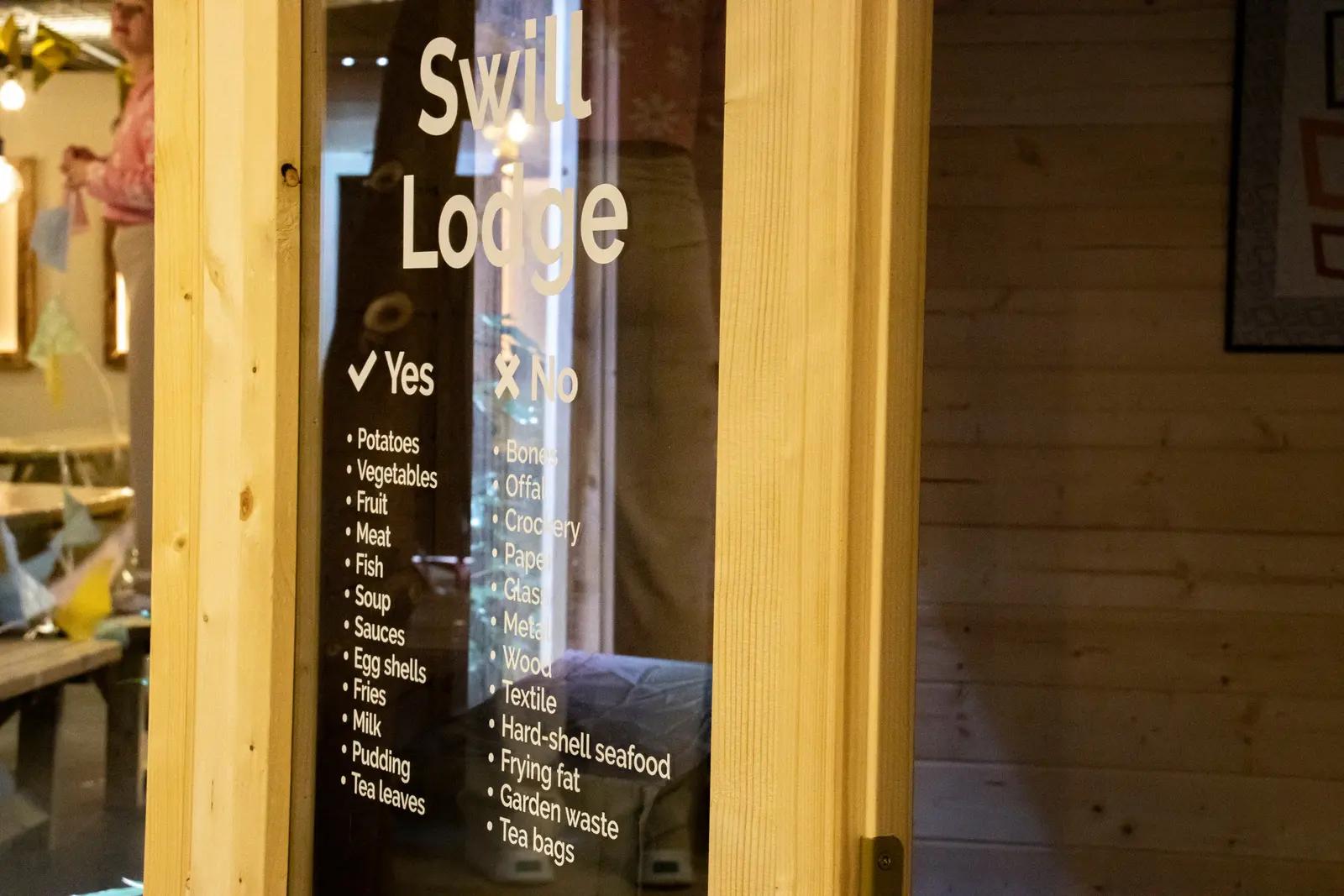Swill Lodge-belettering en informatie op een glazen deur