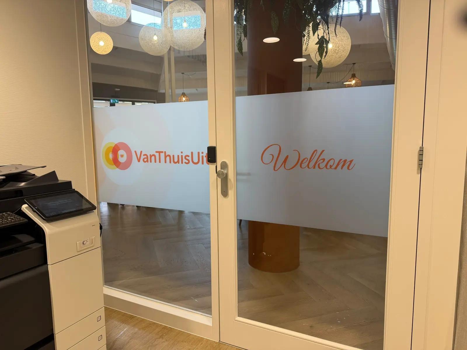 Frosted window film with the VanThuisUit logo and welcome lettering on the internal glazed door.