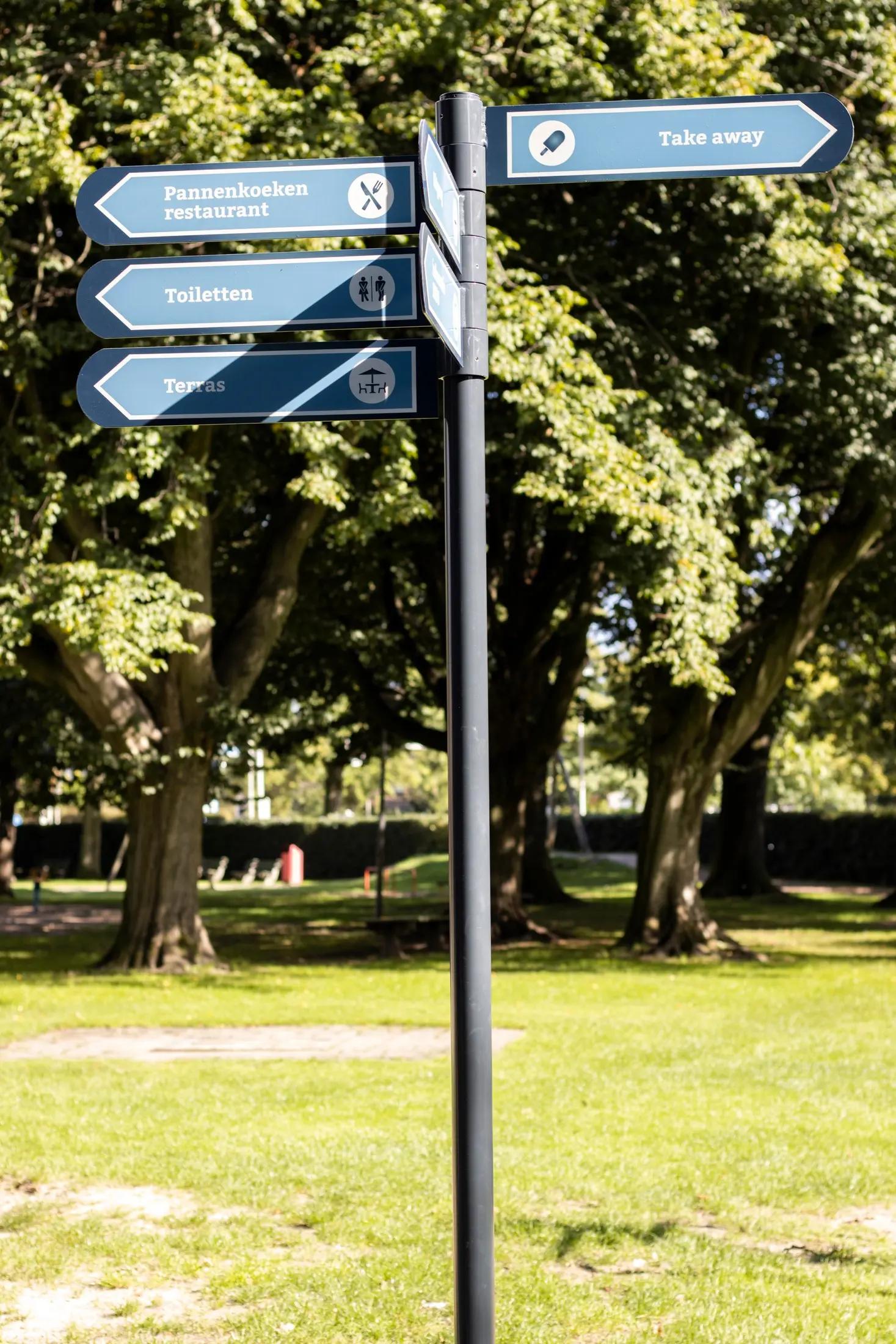 Overzicht van de pijlenpaal in het groene terrein van Vrouwenhof