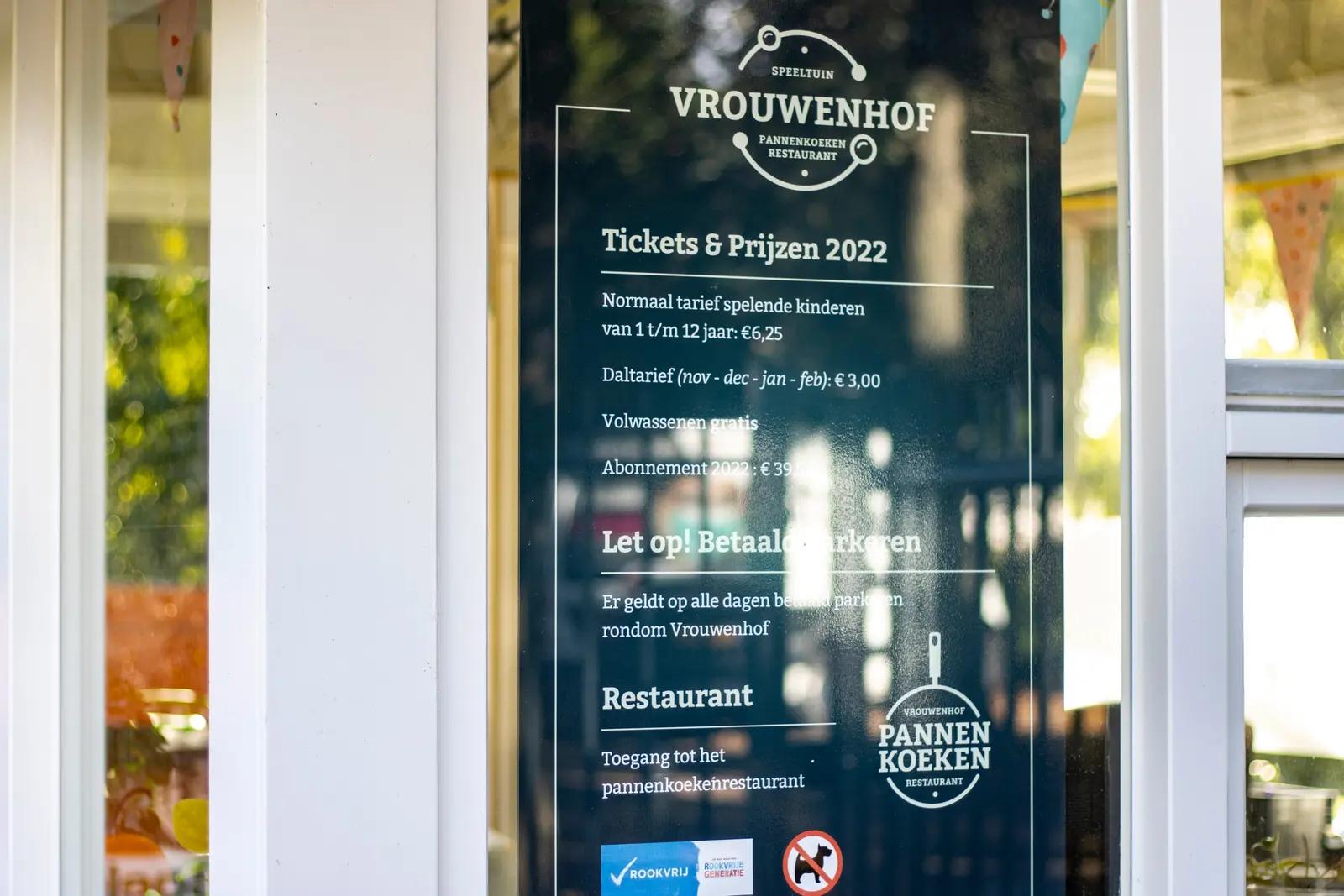 Witte bezoekersinformatie op het glas bij Vrouwenhof