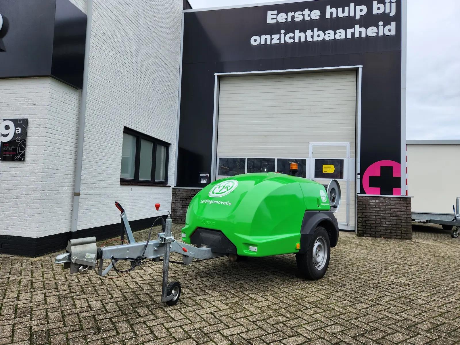 Groene VSR-aanhanger met witte logo’s en belettering op de gebogen behuizing.