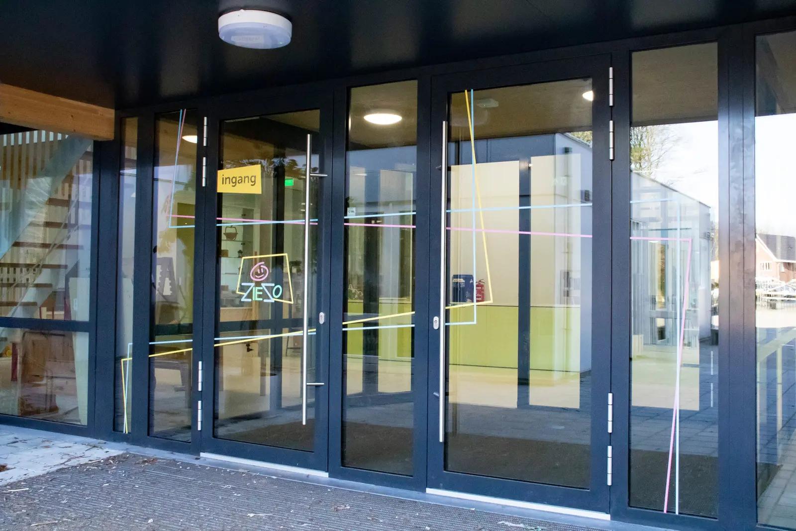 Glass entrance at Basisschool Ziezo with colourful window graphics